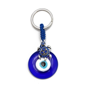 Macro detail of a blue sea turtle keychain with rhinestones and evil eye glass bead