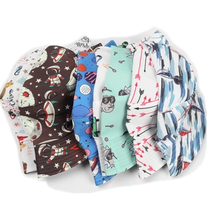 Macro view of reversible bucket hats featuring colorful astronaut and sci-fi galaxy prints