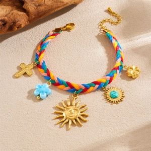 Colorful woven bracelet with gold-plated sun, cross, and flower charms in bohemian style