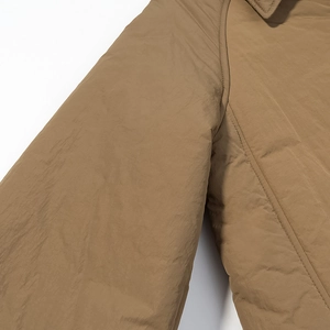 Detail of khaki cotton jacket showing shoulder stitching and textured nylon fabric