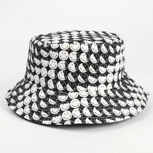 Détail du chapeau bob réversible avec motifs imprimés de visages souriants noir et blanc