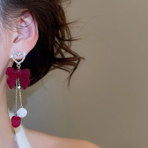Detailed view of silver heart stud earrings with burgundy velvet bow and tassel chain