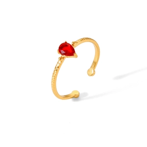 Detail of 18k gold plated ring with red pear-cut zircon and hammered texture finish