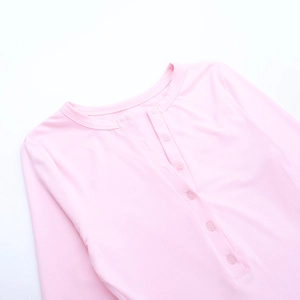 Gros plan détaillé du haut Henley rose à manches longues avec boutons et maille côtelée
