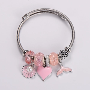 Detail of pink heart, mermaid tail, and pearl charms on silver twisted rope bracelet