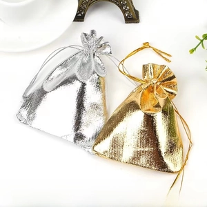 Macro shot of gold and silver metallic drawstring jewelry pouches on a lifestyle background
