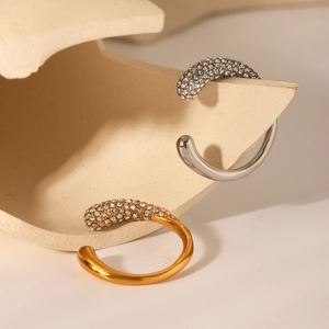 Close-up of gold and silver open bangles with sparkling zircon-set tapered ends