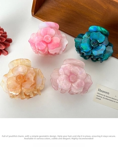 Detailed view of 3D rose hair claws in peach, blue, amber, and pearl pink acetate