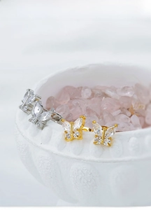 Macro view of titanium steel butterfly earrings with sparkling cubic zirconia inlay
