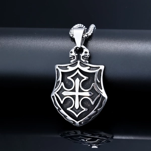 Detail of gothic shield pendant with cross and skull accents on stainless steel necklace