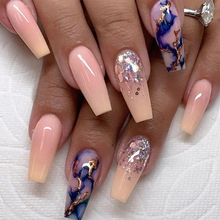 Detail of long coffin nails featuring pink gradients, glitter, and blue marble designs
