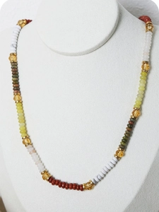 Detail of colorful Bohemian beaded necklace with vibrant resin stones and gold spacers