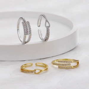 Gold and silver geometric zircon rings with pavé crystals in a crossed design