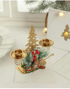 Detail of golden double candle holder with snowflake tree and festive pine decor