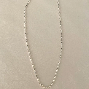 Polished 925 sterling silver beaded necklace with oval rice pearls and round beads on beige
