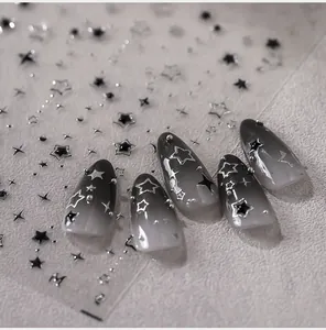 Vue macro des stickers ongles étoiles argentées M-552 avec dégradé noir et blanc chic