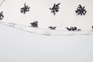 Gros plan sur l'ourlet de robe à fleurs avec dentelle et finitions de couture précises