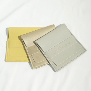 Detailed view of stacked PU leather jewelry pouches in yellow, gold, and light grey colors