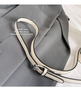 Detail of adjustable cream synthetic leather shoulder strap with silver metal buckle