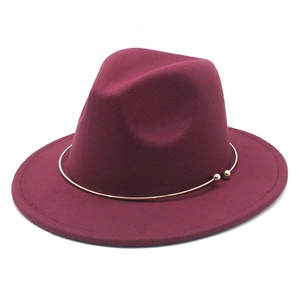 Detail view of burgundy felt fedora hat featuring a stylish gold metal ring accent