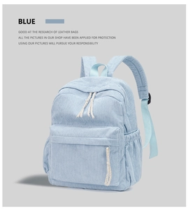 Detail view of light blue corduroy backpack featuring white cotton rope zipper pulls