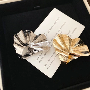 Macro detail of gold and silver ginkgo leaf rings with elegant wrinkled metal texture