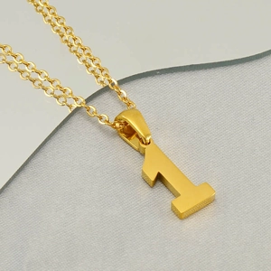 Detailed close-up of a minimalist golden number 1 pendant on a sleek stainless steel chain