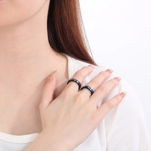 Close-up of geometric stainless steel rings with inset stones on model fingers