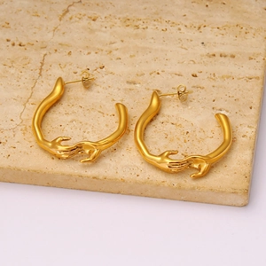 Boucles d'oreilles créoles dorées avec design mains entrelacées au style créatif