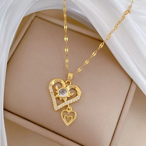Macro shot of double heart zircon pendant with gold titanium chain on jewelry box