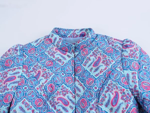 Close-up of quilted winter jacket featuring colorful geometric paisley floral patterns