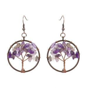 Close-up of handmade tree of life earrings with purple crystals and copper wire wrap