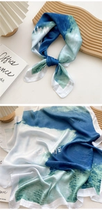 Detail showing sea wave printed silk scarf with blue gradient and Sea Wave text