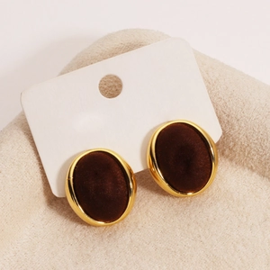 Detail of oval brown flocked earrings with 18K gold plating on a soft plush background