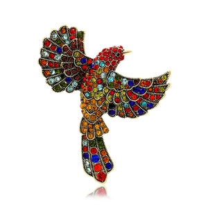 Vintage gold hummingbird brooch with colorful rhinestones in a professional studio shot