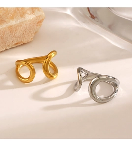 Polished gold and silver minimalist teardrop rings on a decorative stone base