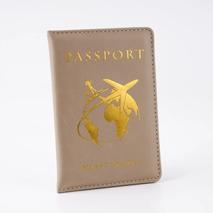 Dettaglio della custodia per passaporto in PU marrone chiaro con stampa dorata di viaggio