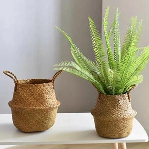 Natural seagrass woven flower basket with handles on white desk for home decoration