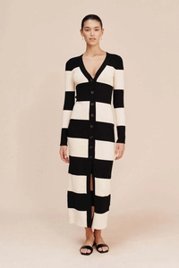 Gros plan sur la maille rayée noir et blanc et le détail boutonné de la robe longue