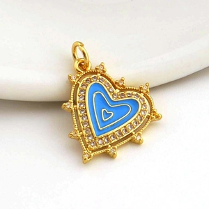 Macro shot of gold-plated heart pendant with light blue enamel and micro-set zircon crystals