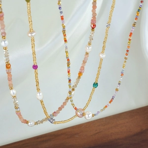 Detail of handmade beaded necklace with freshwater pearls and colorful gemstones
