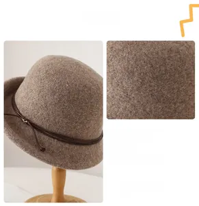 Detail of brown wool cloche hat featuring leather cord trim and fine fabric texture
