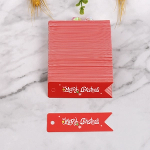 Dettaglio di etichette natalizie in carta rossa con scritta bianca Merry Christmas