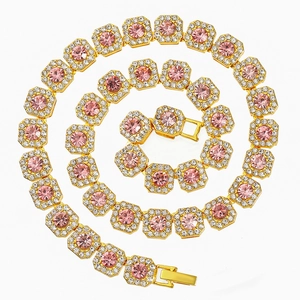 Iced out pink diamond sugar cube Cuban link necklace in gold finish on white background