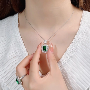 Detail of silver emerald pendant necklace featuring a square green gemstone and fine diamonds