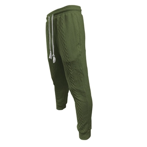 Detail of olive green jacquard knit jogger pants with textured diamond pattern and drawstring