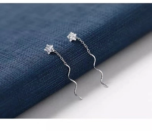 Dettaglio orecchini a stella in argento S925 con nappe a onda e zirconi trasparenti