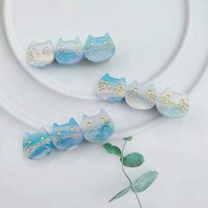 Detailed view of three blue marble gradient cat hair clips on a white ceramic plate