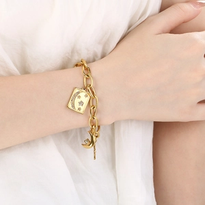 Close-up of 18K gold star and moon pendant bracelet with sparkling crystals on wrist