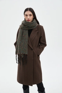 Colorful mixed knit scarf with tassels and woven texture worn by model in brown coat